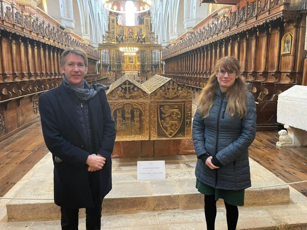 Jonathan Phillips and Natasha Hodgson standing in Burgos Cathedral in front of the tomb of Leonor Plantagenet.